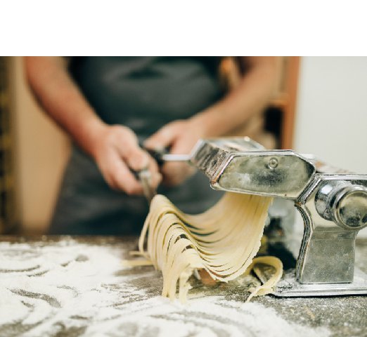 chef-with-knife-hand-cooking-fresh-homemade-fettuccine-pasta-machine-wooden-kitchen-table_Resize